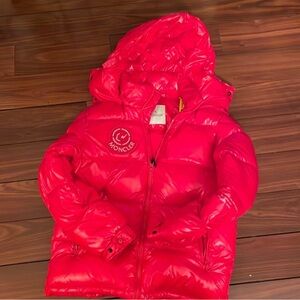 Long sleeve down-filled quilted technical satin jacket in black. Bungee-style